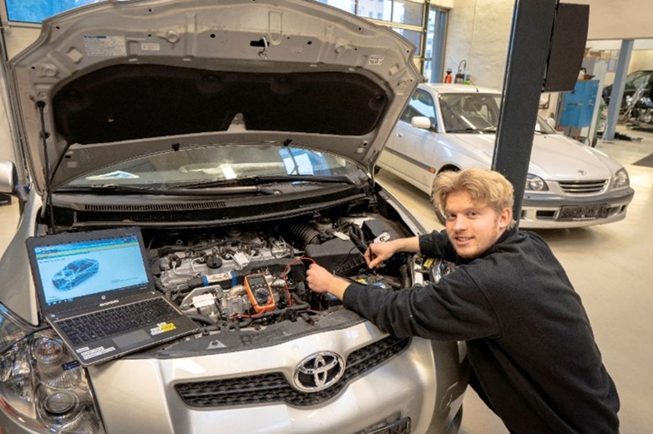Elev foran bil med opent panser
