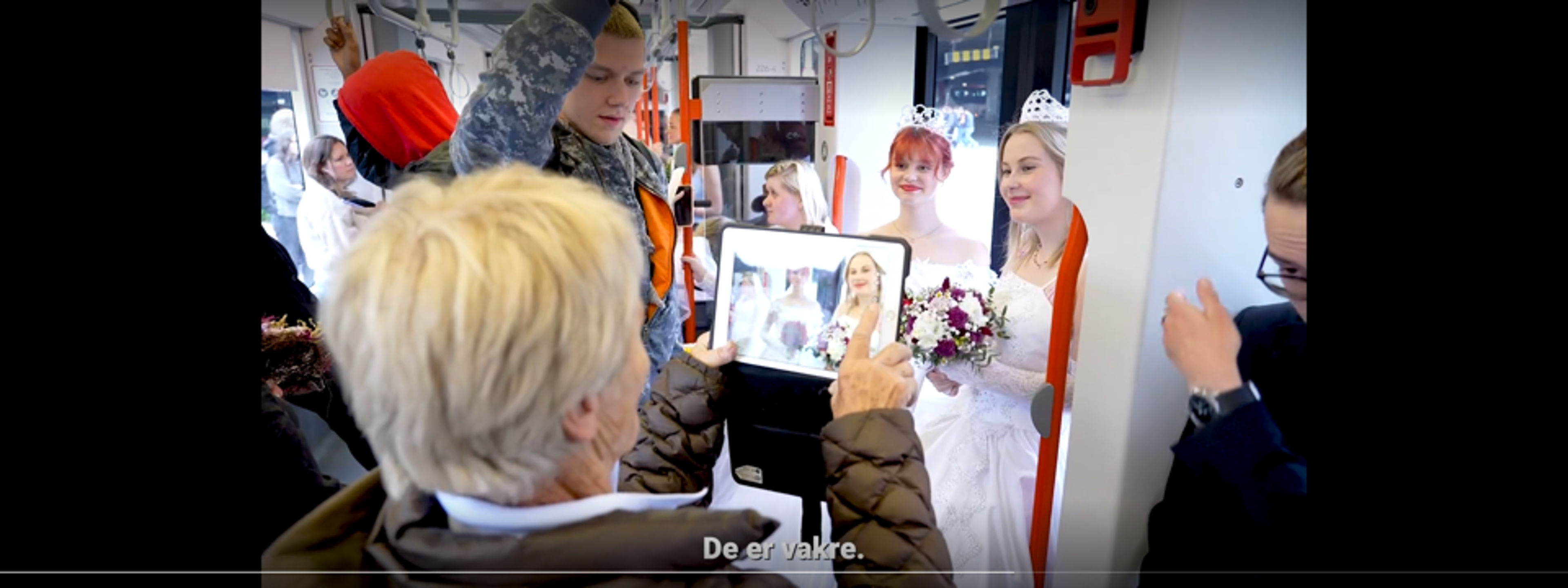 Kvinne tar bilde av elever i brudekjole.