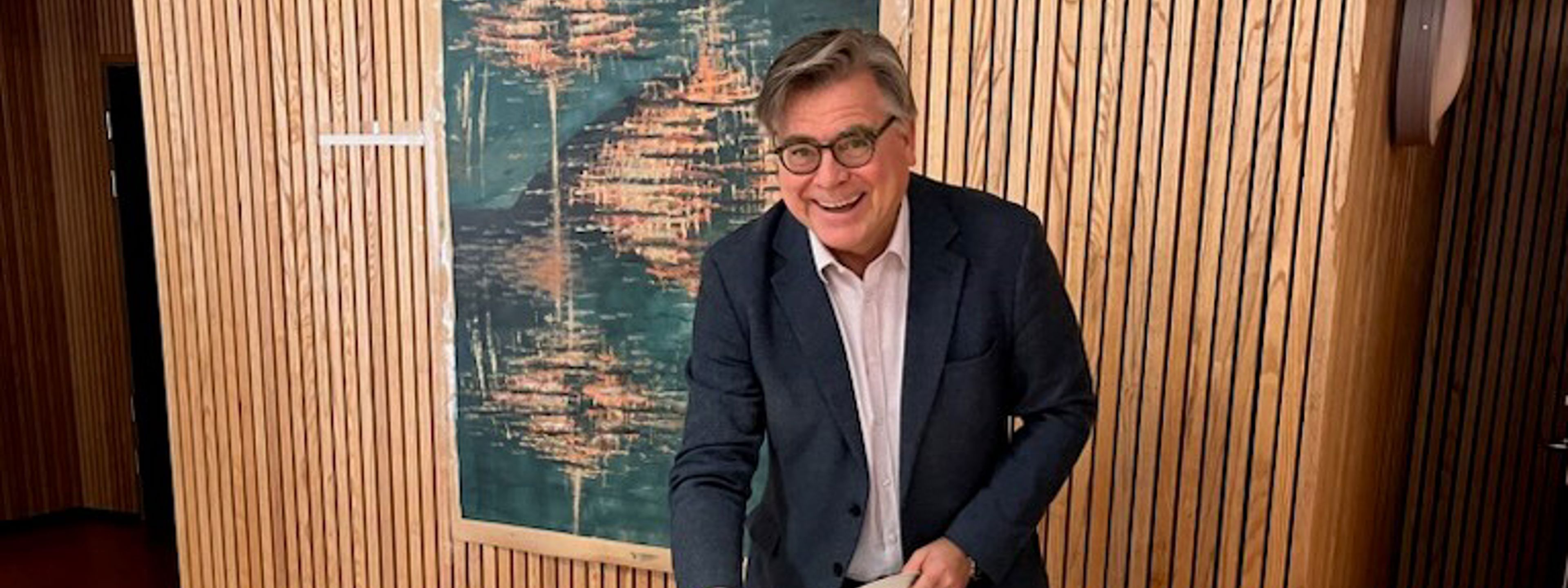 Avtroppende rektor smiler og skjærer opp kake