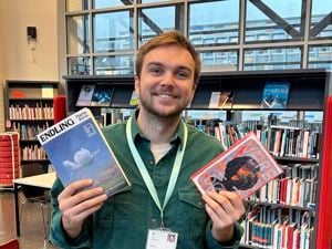 Smilende mann med to bøker i hendene