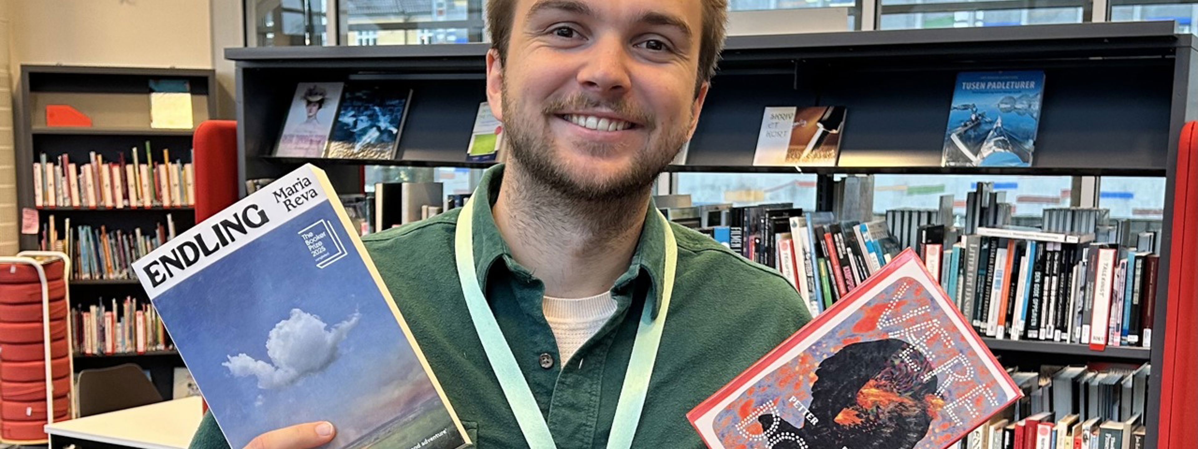 Smilende mann med to bøker i hendene