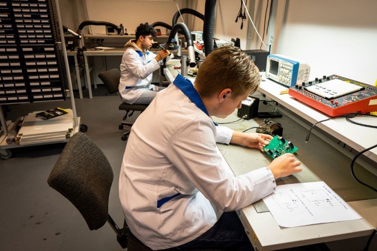 To elevar jobber med komponentar på verkstedet