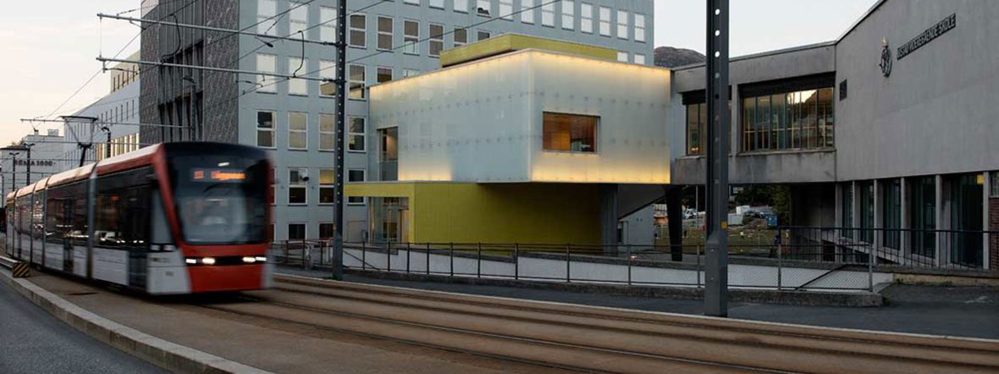 Skolens fasade med bybane foran.